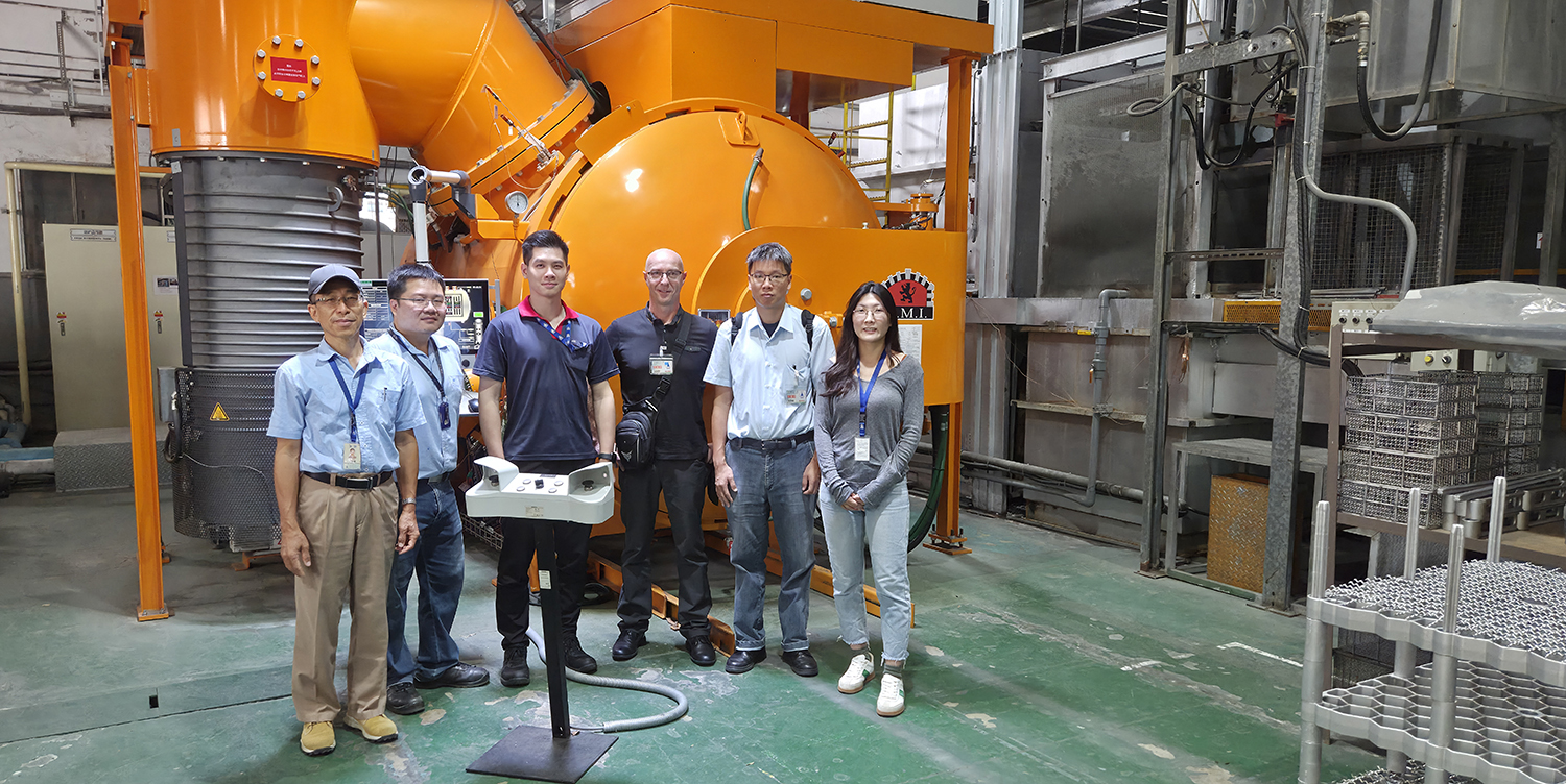 The team in front of AIDC's vacuum furnace